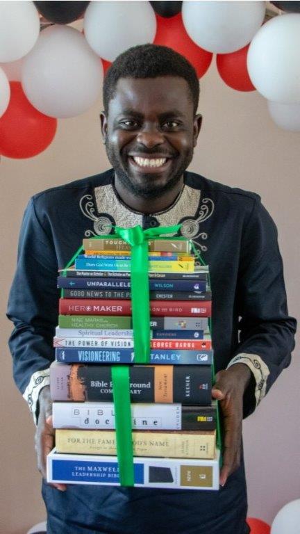 Bible college graduate in Uganda receiving personal library of books
