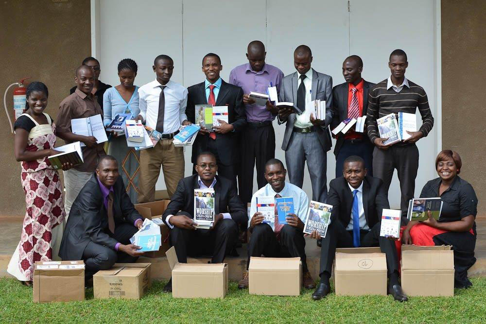 Group of Bible college students in Zambia holding book sets
